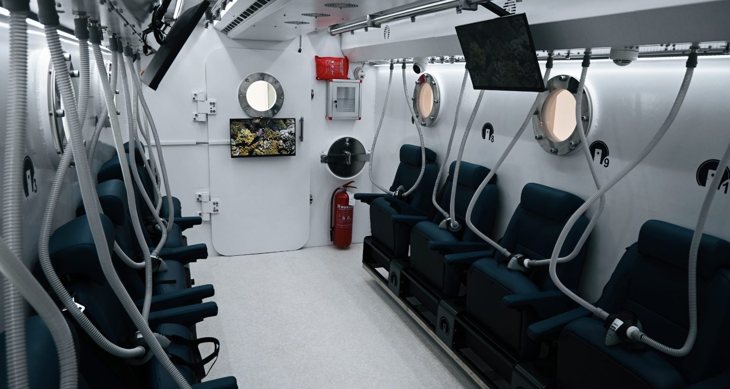 Notranjost hiperbarične komore OxySphere s sedeži in kisikovimi maskami